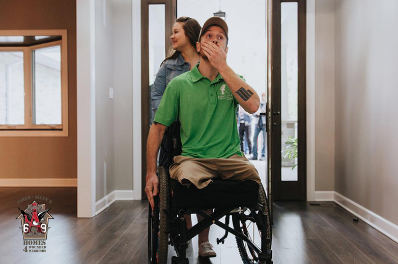 Man in wheelchair with woman entering new house
